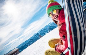 Frau sitzt in Liegestuhl in Winterlandschaft