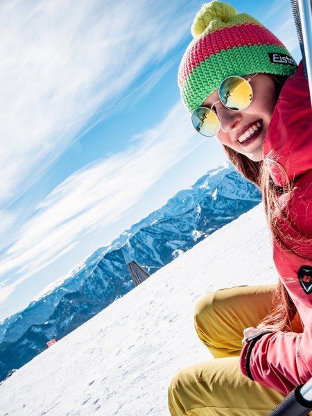 Frau sitzt in Liegestuhl in Winterlandschaft